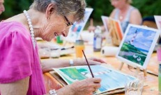 An elder painting outdoors with watercolors