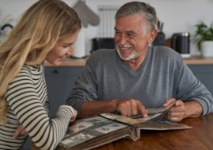 An elder looking through a photo album with a family member